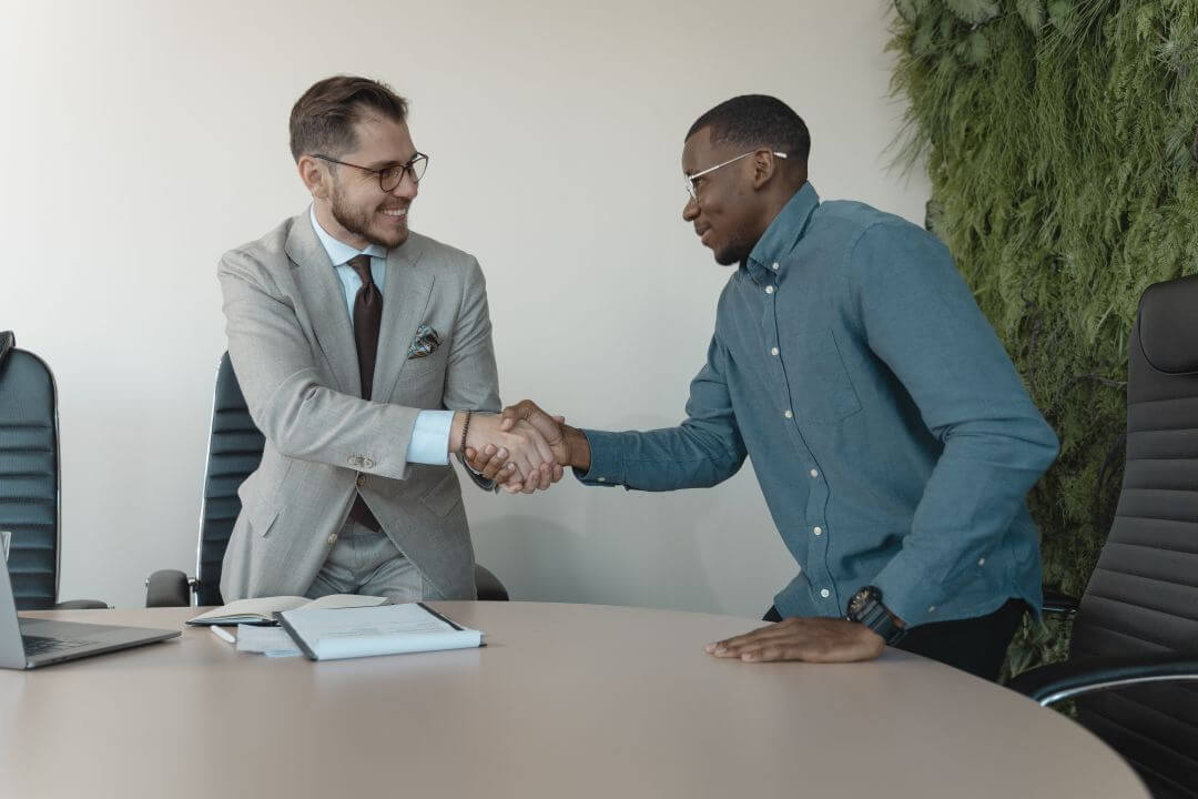 Dois homens em um ambiente de trabalho apertando as mãos
